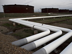 Pipelines run toward oil storage tanks stand at the Enbridge Inc.  storage terminal.