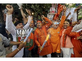 Bharatiya Janata Party (BJP) workers celebrate outside BJP headquarters in New Delhi India, Thursday, May 23, 2019. Indian Prime Minister Narendra Modi and his party have a commanding lead in early vote counting from the country's six-week general election.