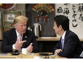 U.S. President Donald Trump, left, speaks with Japan's Prime Minister Shinzo Abe while sitting at a counter during a dinner at the Inakaya restaurant in the Roppongi district of Tokyo, Sunday, May 26, 2019.