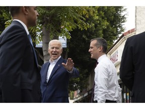Former vice president and Democratic presidential candidate Joe Biden, left, waves toward members of the media as he and Los Angeles Mayor Eric Garcetti leave King Taco after talking to patrons Wednesday, May 8, 2019, in Los Angeles.