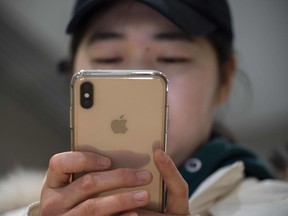 A woman uses an Apple iPhone at a shopping mall in Beijing.