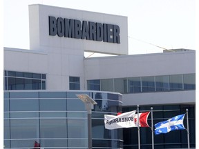 Flags fly outside a Bombardier plant in Montreal, Thursday, May 14, 2015. Bombardier Inc. says it is looking to sell its aerostructures businesses in Belfast and Morocco as part of a consolidation of its aerospace business into a single unit.