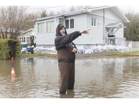 Statistics Canada says almost 3,800 business locations were at risk of being affected by spring flooding in three of the hardest hit regions of the country. Jean-Francois Cadieux stands in his driveway surrounded by floodwaters on Ile Bizard west of Montreal, Saturday, April 27, 2019.