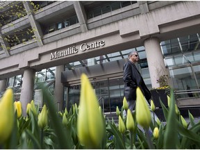 A man walks by the Manulife Centre in Toronto the day of the Manulife Financial Annual General Meeting on Thursday May 3, 2012.