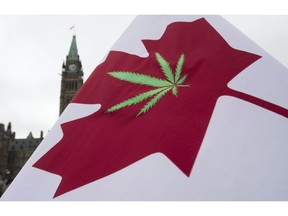 A Canadian flag with a cannabis leaf flies on Parliament Hill during the 4/20 protest, Monday, April 20, 2015 in Ottawa. Health Canada says it is changing its process for issuing cannabis licenses in a bid to reduce wait times and use the government agency's resources more efficiently.
