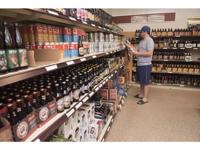 A customer shops in the craft beer section of the NB Liquor store in Fredericton, N.B., on Friday, June 16, 2017. What a difference a week makes ??? at least when it comes to employee and management bonuses at NB Liquor. The Crown-owned liquor corporation had to pay out almost $405,000 in extra sales incentive and executive bonus payments at the end of the 2017-18 fiscal year because they had to add an extra week to the 4th quarter.
