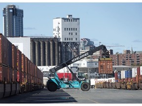 Shipping containers are moved at the Halterm Container Terminal in Halifax on Friday, Oct. 19, 2018. PSA International Pte Ltd. says it has secured a deal to buy the largest container terminal in Eastern Canada.