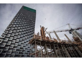 Workers assemble concrete forms at a condo tower under construction, in Vancouver on Friday, Oct. 26, 2018. Preconstruction condominiums present a tempting opportunity for many prospective buyers who want something brand new or need a little more time to save money for the purchase.