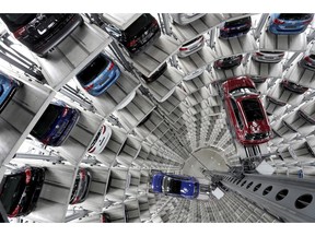 FILE - In this March 14, 2017 file photo Volkswagen cars are lifted inside a delivery tower of the company in Wolfsburg, Germany. German automaker Volkswagen saw operating profit slip in the first quarter 2019 as the company set aside 1 billion euros for legal issues but reaffirmed its profit goals for the year and saw better profits at its core brand.