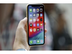 FILE - This Sept. 12, 2018, file photo shows an Apple iPhone XR on display at the Steve Jobs Theater after an event to announce new products, in Cupertino, Calif. A Chinese national in Oregon sent hundreds of supposedly broken iPhones to Apple over two years, and got replacements under warranty of almost 1,500 devices.