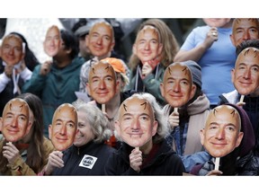 FILE - In this Oct. 31, 2018, file photo, demonstrators hold images of Amazon CEO Jeff Bezos near their faces during a Halloween-themed protest at Amazon headquarters over the company's facial recognition system, "Rekognition," in Seattle. San Francisco is on track to become the first U.S. city to ban the use of facial recognition by police and other city agencies as the technology creeps increasingly into daily life. Studies have shown error rates in facial-analysis systems built by Amazon, IBM and Microsoft were far higher for darker-skinned women than lighter-skinned men.