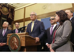 FILE - In this April 29, 2019, file photo, Gov. Jay Inslee, surrounded by Democratic lawmakers from the Senate and House, talks to the media following the Washington Legislature adjourning its 105-day legislative session in Olympia, Wash. Inslee is expected to sign legislation making Washington the first state to enter the private health insurance market with a universally available public option.