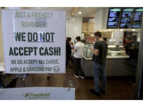 This Thursday, May 2, 2019, photo shows a sign posted on a door alerting customers that cash is not accepted at Freshroll Vietnamese Rolls and Bowls in San Francisco. San Francisco is about to require brick-and-mortar retailers to take cash in payment for goods, joining Philadelphia and New Jersey in banning a practice that critics say discriminates against the poor.