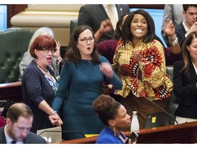 Illinois state Senator Heather Steans, D-Chicago, left, state Reps. Kelly Cassidy, D-Chicago and Jehan Gordon-Booth, D-Peoria, react as they watch the final votes come in for their bill in the Illinois House chambers to legalize recreational marijuana use Friday, May 31, 2019. The 66-47 vote sends the bill to Gov. J.B. Pritzker who indicated he will sign it.