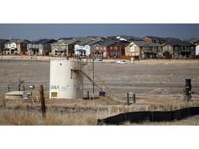 FILE - This Feb. 28, 2019 file photo shows a storage tank near a well pad located in a field near a housing development in Broomfield, Colo. The newly reorganized Colorado Oil and Gas Commission planned to meet Tuesday, May 21, 2019, and will later begin rewriting state rules to emphasize public safety and the environment instead of production. A new Colorado law weakens industry influence on the commission while adding experts in public health and wildlife. The law reflects increasing fears about public safety as a booming oil and gas field north and east of Denver overlaps with fast-growing communities.