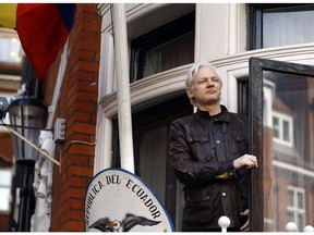 FILE - In this Friday, May 19, 2017 file photo, WikiLeaks founder Julian Assange looks out from the balcony while claiming political asylum at the Ecuadorian embassy in London. Assange was arrested by British police April 11, 2019, after his asylum was withdrawn by the embassy, and he is set to appear in court Wednesday May 1, 2019, to be sentenced for jumping British bail seven years ago and holing up in the Ecuadorian embassy.