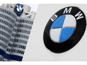 FILE-In this March 21, 2018 file photo shows the logo of German car manufacturer BMW visible at the headquarters in Munich, Germany. German automaker BMW said Tuesday that its first quarter profit sagged by 74 percent as earnings were hit by a 1.4 billion-euro ($1.6 billion) set-aside for an anti-trust fine from the European Commission and by higher up-front costs for new technology and factories.