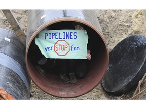 Activists occupy a German pipeline in Wrangelsburg, northern Germany, Thursday, May 16, 2019. Police say activists have occupied a building site in northern Germany to protest against the ongoing Nord Stream 2 pipeline project with Russia. The sign reads 'Pipelines plug".