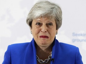Britain's Prime Minister Theresa May grimaces as she delivers a keynote speech in central London on Tuesday.