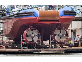 In this Thursday, May 16, 2019 photo a worker walks beside ship's screws at a dockyard at the harbor in Bremerhaven, Germany. The city became a battleground for EU's fragile political center, support for Germany's Social Democrats has ebbed dramatically in recent years, but nowhere is their fate more closely watched than in the tiny city-state of Bremen.