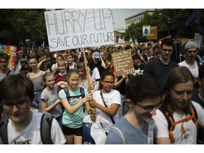 Students hold posters as they attend a protest rally of the 'Friday For Future' movement in Berlin, Germany, Friday, May 24, 2019. The German language poster reads: 'The best time to plant a tree was 20 years ago. The next best time is now'.