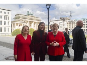 German Chancellor Angela Merkel,right, German Environment Minister Svenja Schulze, left, and Chilean Environment Minister Carolina Schmidt, center, pose for media in front of the Brandenburg Gate prior to a session of the 10th 'Petersberger Klimadialog' climate conference in Berlin, Germany, Tuesday, May 14, 2019.