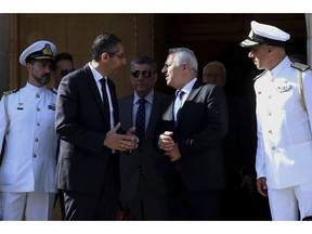 Cyprus' defense Minister Savvas Angelides, second left, talks with his Greek counterpart Evaggelos Apostolakis after their meeting with Cyprus' president Nicos Anastasiades at the presidential palace in Nicosia, Cyprus, Wednesday, May 8, 2019. Cyprus says it will rally support from fellow European Union countries and others to counter Turkey's bid to drill in waters where the east Mediterranean island nation has exclusive economic rights.