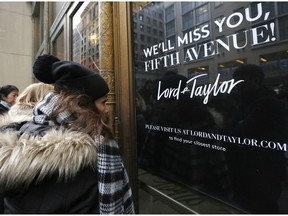 FILE - In this Jan. 2, 2019, file photo women peer in the front door of Lord & Taylor's flagship Fifth Avenue store which closed in New York. Lord & Taylor, one of the country's oldest department stores, may be sold as its owner considers its options. Hudson's Bay Co., which also owns Saks Fifth Avenue, says it hired a financial adviser to review Lord & Taylor's business and that the process may lead to a sale or merger.