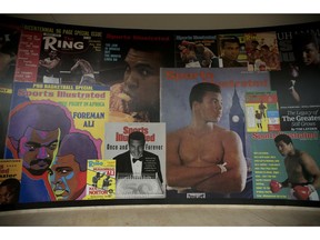 FILE - In this June 4, 2016, file photo large posters of mostly Sports Illustrated magazine covers are displayed at the "I Am The Greatest, Muhammad Ali" exhibition at the O2 arena, which hosts high profile boxing fights in London. Sports Illustrated is being sold for $110 million, but the seller will continue running the iconic magazine under a licensing deal. Authentic Brands Group is buying Sports Illustrated from Meredith Corp.