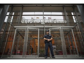 FILE- In this June 28, 2018, file photo, a police officer stands guard outside The New York Times building in New York. The New York Times Co. reports financial results Wednesday, May 8, 2019.