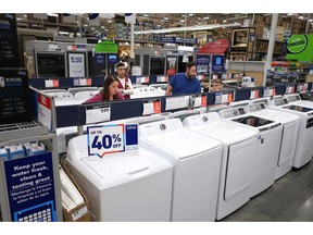 FILE- In this May 21, 2018, file photo, a family shops for washing and drying machines at Lowe's Home Improvement store in East Rutherford, N.J. Lowe's Companies Inc. reports earnings on Wednesday, May 22, 2019.