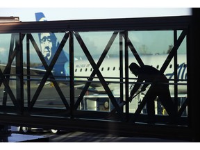 FILE- In this March 4, 2019, file photo a worker cleans a jet bridge before passengers boarded an Alaska Airlines flight to Portland, Ore., at Paine Field in Everett, Wash. U.S. employers are expected to have delivered a solid month of job growth in April, buoyed by a resilient economy that has confounded concerns that 2019 would begin with a slowdown. Another decent hiring gain would highlight the economy's steady health just months after many analysts had expressed fear that growth was poised to weaken and a recession might soon occur.