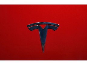 FILE- This Oct. 3, 2018, file photo shows the logo of Tesla model 3 at the Auto show in Paris. Tesla is increasing the size of its stock and debt offering to as much as $2.7 billion just one day after announcing plans to raise $2 billion in new capital. The Palo Alto, California, electric car and solar panel maker says it is increasing the offer due to the response from an announcement made Thursday, May 2, 2019.