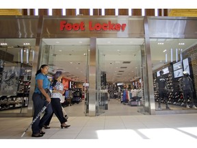 FILE - In this Aug. 22, 2017 file photo, shoppers walk past a Foot Locker store in Hialeah, Fla. Foot Locker Inc. (FL) on Friday, May 24, 2019, reported fiscal first-quarter earnings of $172 million. The New York-based company said it had profit of $1.52 per share. Earnings, adjusted for non-recurring costs, were $1.53 per share.