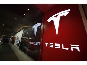 FILE- In this Feb. 9, 2019  file photo, a sign bearing the company logo is displayed outside a Tesla store in Cherry Creek Mall in Denver.  A new automatic lane-change feature of Tesla's Autopilot system doesn't work well and could be a safety risk to drivers, according to tests performed by Consumer Reports. Senior Director of Auto Testing Jake Fisher said in a statement Wednesday, May 22,  that the system doesn't appear to react to brake lights or turn signals, and it can't anticipate what other drivers will do.
