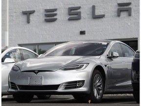 FILE - This July 8, 2018 photo shows Tesla 2018 Model 3 sedans sit on display outside a Tesla showroom in Littleton, Colo. Late last year, Tesla Inc. was fully charged and cruising down the highway on Autopilot. Shares were trading above $370 each, sales of the Model 3 small electric car were strong and the company had appointed a new board chair to rein in the antics of CEO Elon Musk. But around the middle of December 2018, investors started having doubts about the Wall Street darling's prospects for continued growth. The stock started a gyrating fall that was among the worst in company history.