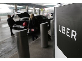 FILE - In this March 15, 2017, file photo, a sign marks a pick-up point for the Uber car service at LaGuardia Airport in New York. Drivers for ride-hailing giants Uber and Lyft are planning to turn off their apps to protest what they say are declining wages at a time when both companies are raking in billions of dollars from investors.