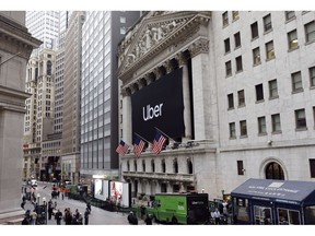 FILE - In this May 10, 2019, file photo, an Uber banner hangs on the facade of the New York Stock Exchange. Uber is continuing to bleed money even as it posts dramatic revenue growth. In its first financial release since its lackluster IPO, Uber reported Thursday, May 30, that revenue rose in the first quarter of 2019, up 20% from the same time last year.
