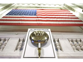 FILE- In this May 17, 2018, file photo an American flag hangs above the bell podium on the floor of the New York Stock Exchange. The U.S. stock market opens at 9:30 a.m. EDT on Wednesday, May 1, 2019.