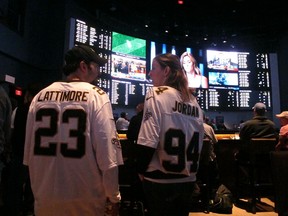 In this Sept. 9, 2018 photo, football fans wait for kickoff in the sports betting lounge at the Ocean Casino Resort in Atlantic City, N.J. Since sports betting became legal last year in New Jersey, the state's casinos and racetracks had taken more than $2.6 billion worth of bets through the end of April 2019.
