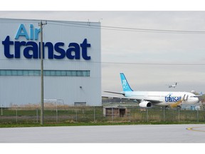 An Air Transat plane is seen as an Air Canada plane lands at Pierre Elliott Trudeau International Airport in Montreal on Thursday, May 16, 2019.