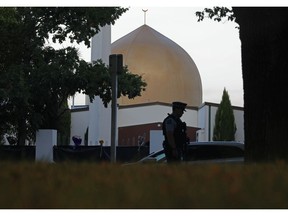 FILE - In this March 17, 2019, file photo, a police officer stands guard in front of the Al Noor mosque in Christchurch, New Zealand. New Zealand's major media organizations pledged Wednesday, May 1, 2019, not to promote white supremacist ideology when covering the trial of the man charged with killing 50 people at two mosques.