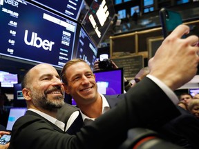 Uber CEO Dara Khosrowshahi, left, and Ryan Graves, a board member, pose for a photo before the company lists during its initial public offering at the New York Stock Exchange, Friday.