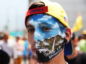 Supporter of Venezuelan opposition leader Juan Guaidó shows his painted face during a demonstration at avenida Francisco de Miranda on May 1, 2019 in Caracas, Venezuela