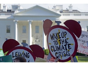FILE- In this June 1, 2017 file photo, protesters gather outside the White House in Washington to protest President Donald Trump's decision to withdraw the Unites States from the Paris climate change accord. The Democratic-controlled House has approved legislation that would prevent President Donald Trump from following through on his pledge to withdraw the U.S. from a landmark global climate agreement.