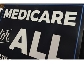 FILE - In this April 10, 2019 file photo, a sign is shown during a news conference to reintroduce "Medicare for All" legislation, on Capitol Hill in Washington. The "Medicare for All" proposal from leading Democrats running for president appears more lavish than what's offered in other advanced countries.
