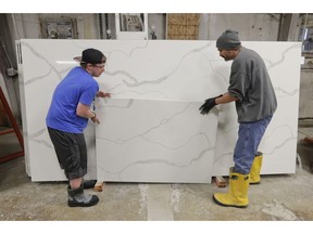 Workers move imported quartz slabs from China in the warehouse at Marble Uniques in Tipton, Ind., on May 3, 2019. The Trump administration's trade warriors are fighting obscure battles over laminated woven sacks from Vietnam, for example, olives from Spain and rubber bands from Thailand. The International Trade Commission in Washington this week will provide an arena for combat over kitchen and bathroom countertops _ or at least the imported quartz slabs that many of them come from.