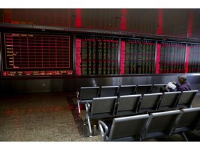 An investor looks at the stock marked on a paper as he monitors stock prices at a brokerage house in Beijing, Monday, May 13, 2019. Shares were mostly lower in Asia on Monday after trade talks between the U.S. and China ended Friday without an agreement.