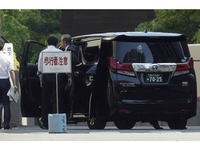 Former Nissan chairman Carlos Ghosn, right, gets off a car as he arrives at Tokyo District Court for a pre-trial meeting Thursday, May 23, 2019, in Tokyo. Ghosn, who is out on bail, has been charged with under-reporting his post-retirement compensation and breach of trust in diverting Nissan money and allegedly having it shoulder his personal investment losses.