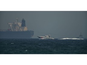 An Emirati coast guard vessel passes an oil tanker off the coast of Fujairah, United Arab Emirates, Monday, May 13, 2019. Saudi Arabia said Monday two of its oil tankers were sabotaged off the coast of the United Arab Emirates near Fujairah in attacks that caused "significant damage" to the vessels, one of them as it was en route to pick up Saudi oil to take to the United States.